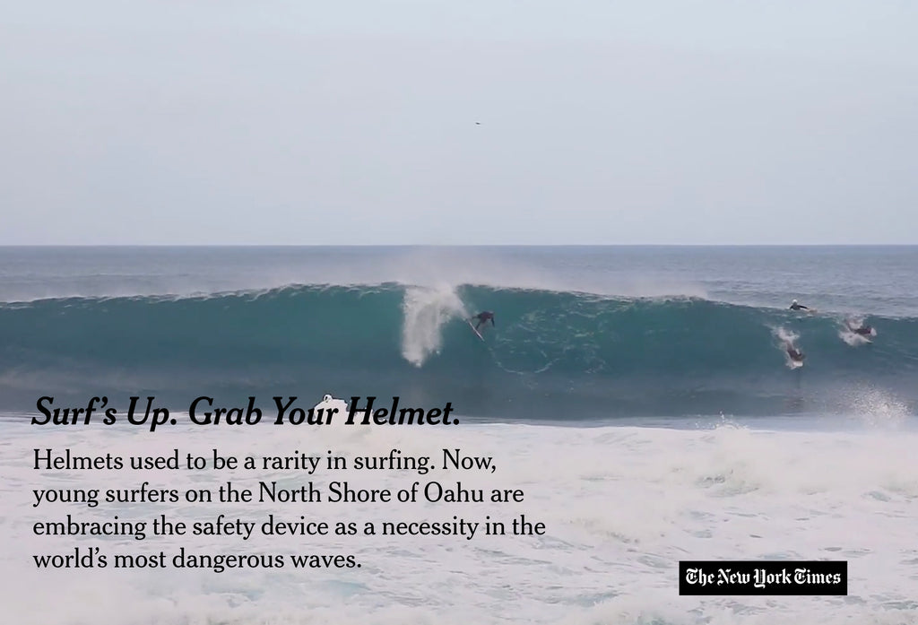 Surfer standing onshore at Pipeline wearing a surf helmet